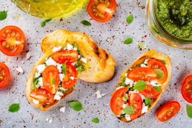 Bruschetta pesto sosu, beyaz peynir, domates ve fesleğen ile