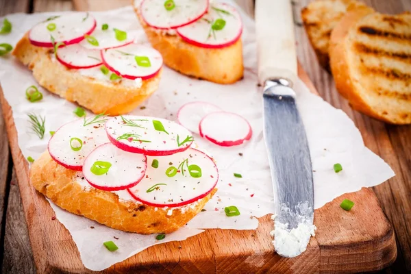 Toasts with cream cheese, organic radish, onion and dill — Stock Photo, Image