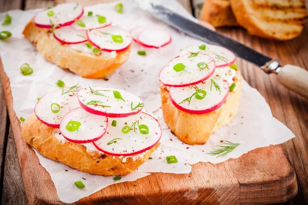 Toasts with cream cheese, organic radish, onion and dill — Stock Photo, Image