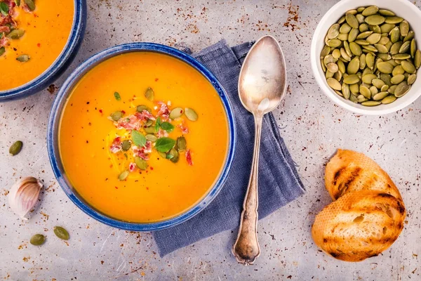 Homemade autumn butternut squash soup with pumpkin seeds, bacon and basil — Stock Photo, Image