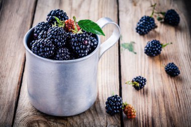 juicy fresh organic blackberries in old mug  clipart