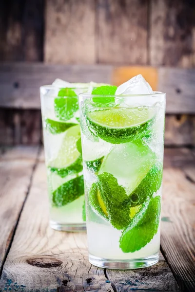 Cócteles mojitos frescos con lima, menta y hielo en vaso —  Fotos de Stock