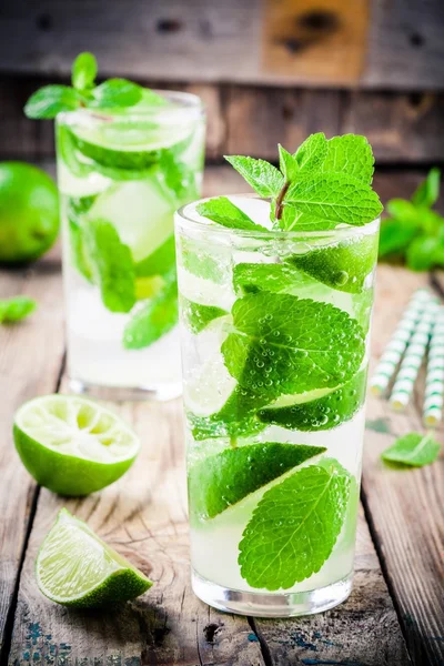 Fresh cocktails with lime, mint and ice in glass — Stock Photo, Image