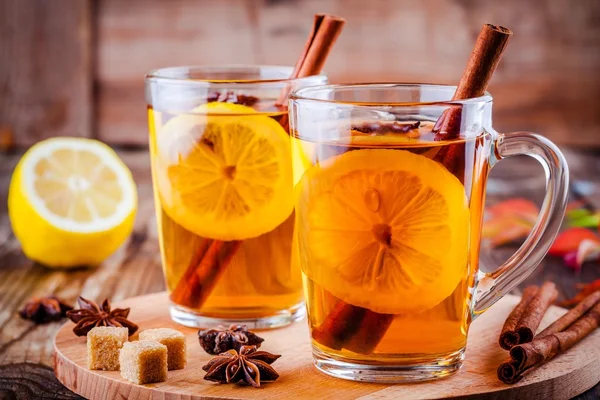Varmt te med citron, anis och kanel i glas muggar — Stockfoto