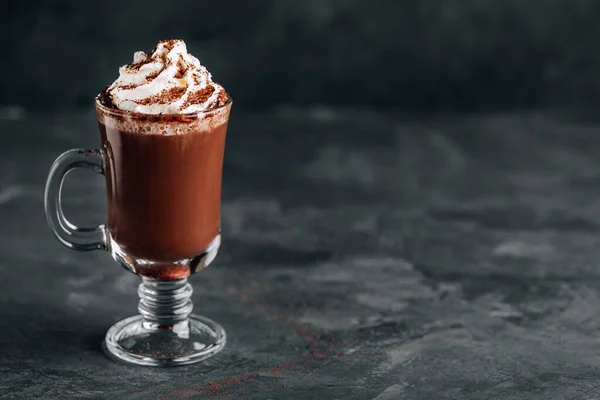暗い背景にガラスにホイップクリームとホットチョコレートココア コピースペース クリスマスのための伝統的な飲み物 — ストック写真
