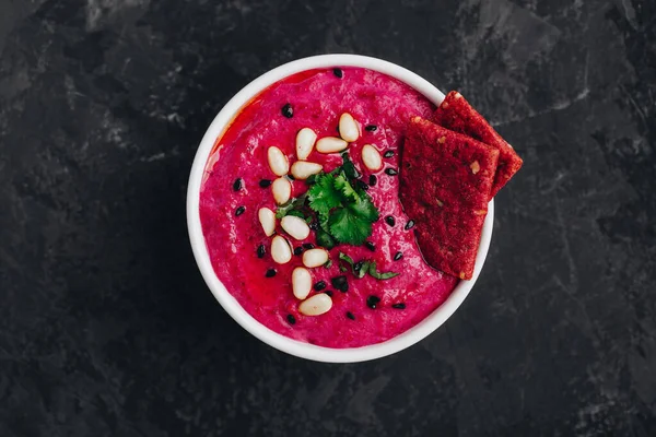 Pancar pancarı Humus ve çıtır ekmek. Sağlıklı vejetaryen dalış koyu taş arkaplan, kopyalama alanı.