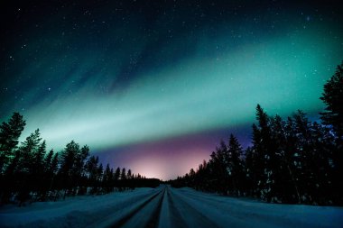 Kuzey ışıkları Aurora Borealis kışın Finlandiya ve Laponya 'da yol üzerinde faaliyet gösteriyor.