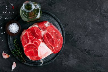 Saf Osso Buco eti, koyu taştan arka planda baharatlar. Kopyalama alanı olan üst görünüm.