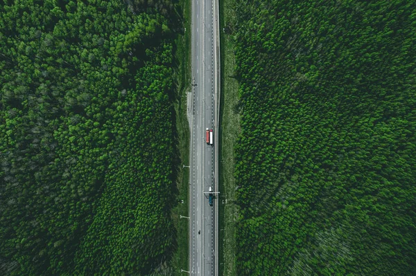 緑豊かな夏の森を通って車やトラックと有料道路の空中ビュー — ストック写真