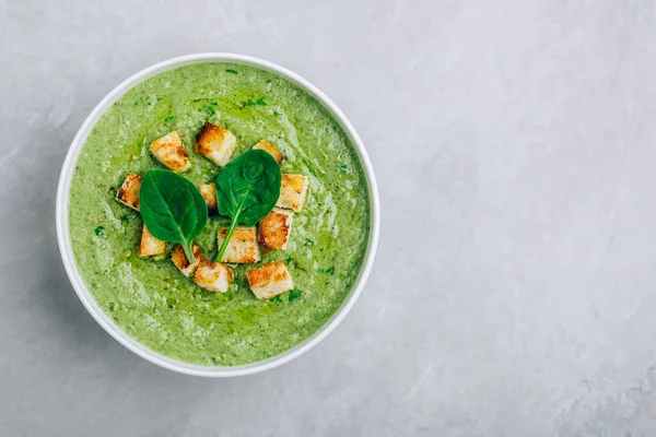 Yeşil Krema Çorbası. Ispanak brokoli kremalı çorba ve gri taşlı arka planda kızarmış ekmek. Kopyalama alanı olan üst görünüm.