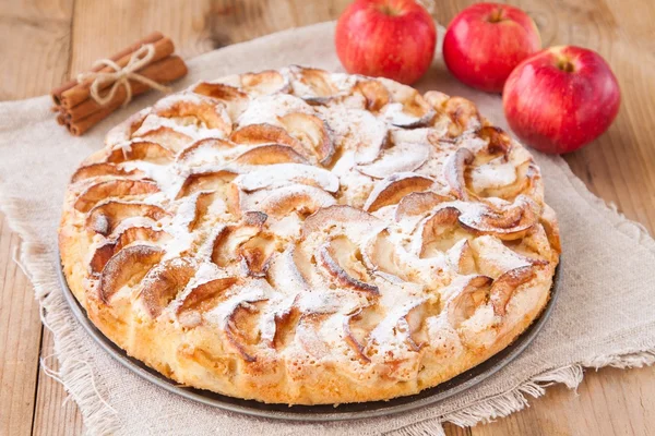 Torta de maçã em um fundo de madeira com canela — Fotografia de Stock