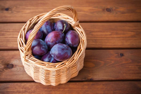 Organic ripe plums in a basket — Stock Photo, Image