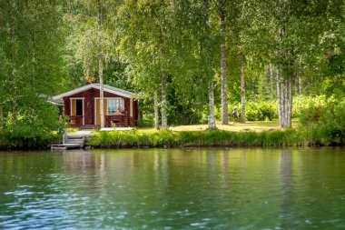 Cottage by the lake in rural Finland clipart