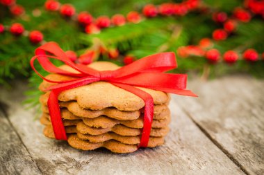 Noel gingerbread çerezleri kırmızı kurdele bir rustik ahşap zemin üzerine
