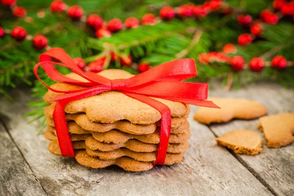Noel gingerbread çerezleri kırmızı kurdele bir rustik ahşap zemin üzerine — Stok fotoğraf
