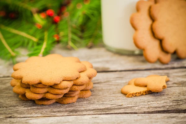 Christmas gingerbread cookies on a rustic wooden background with milk — Stock Photo, Image