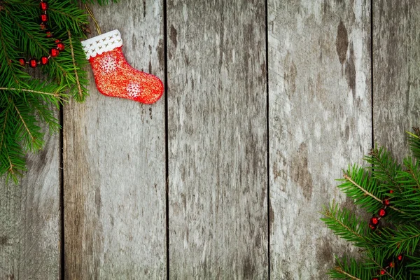 Сосна с красным носком и гирляндой на старом деревянном фоне — стоковое фото