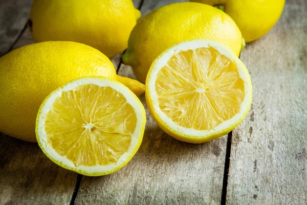Свежие сочные лимоны на деревянном фоне — стоковое фото