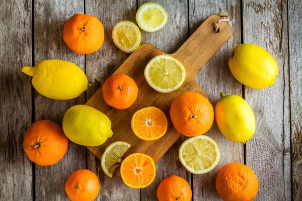 Спелые мандарины и лимоны на доске — стоковое фото