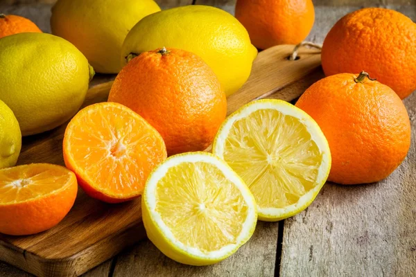 Ripe mandarins and lemons on a cutting board — Stock Photo, Image