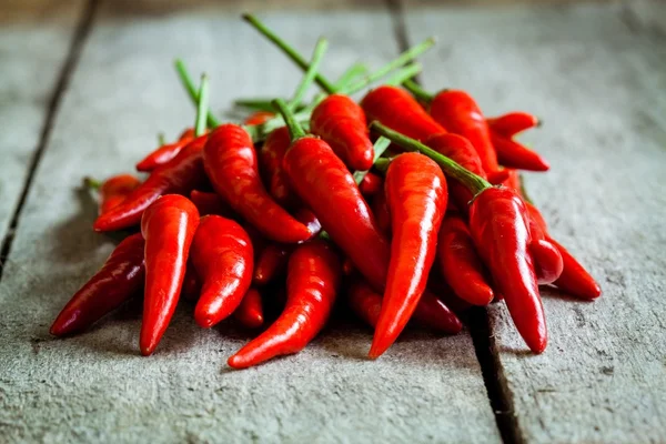 Red hot chili peppers on a wooden background — Stock Photo, Image