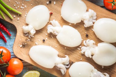 Bir kesme tahtası portre üzerinde ham bebekler mürekkep balığı