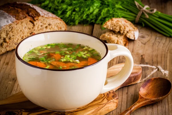 Sopa de legumes em uma xícara em um fundo de madeira — Fotografia de Stock