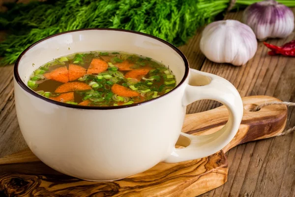 Groentesoep in een cup op een houten achtergrond — Stockfoto