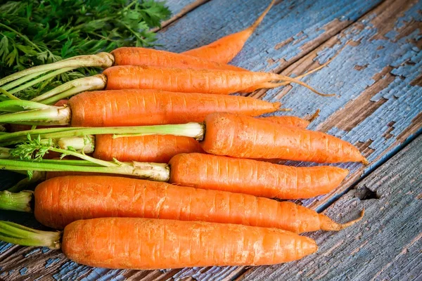 Ramo de zanahorias frescas sobre fondo de madera — Foto de Stock