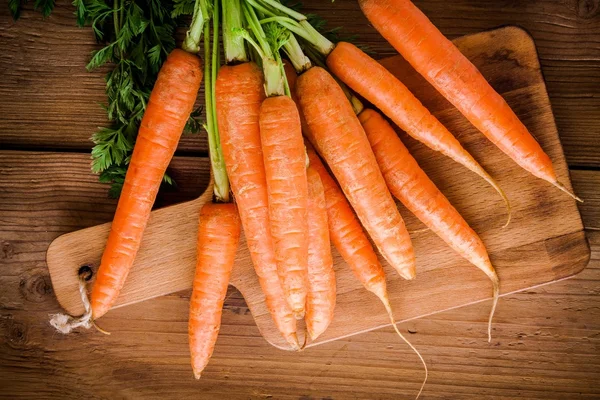 Fresh carrots bunch on cutting board — Stock Photo, Image
