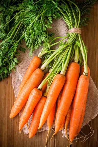 Fresh organic carrots bunch on wooden background — Stock Photo, Image