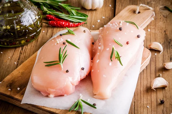 Filete de pollo crudo con ajo, pimienta, aceite de oliva y romero —  Fotos de Stock