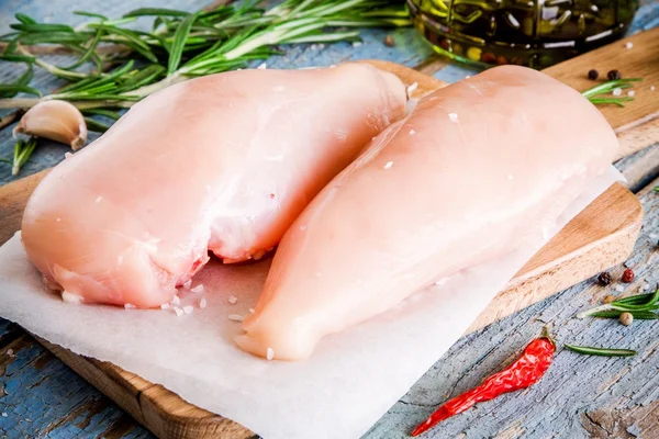 Rohes Hühnerfilet mit Knoblauch, Pfeffer und Rosmarin Nahaufnahme — Stockfoto