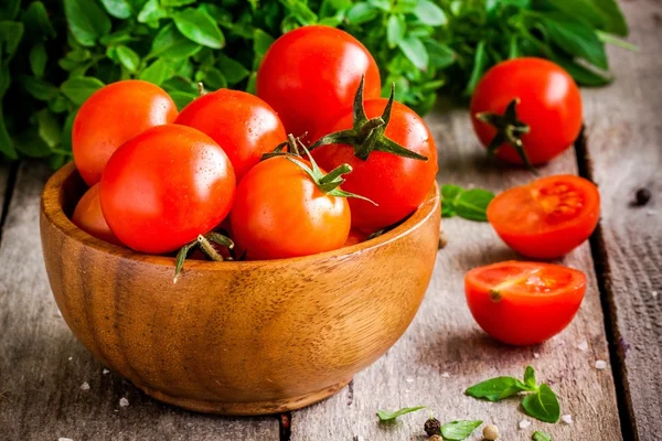 Tomates cereja na tigela, manjericão orgânico fresco — Fotografia de Stock