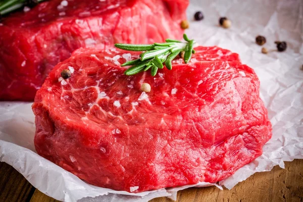 Deux steaks crus au romarin, sel et poivre en gros plan — Photo