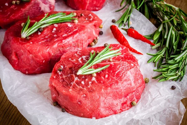 Biberiye, sarımsak, tuz ve biber ile iki çiğ biftek — Stok fotoğraf