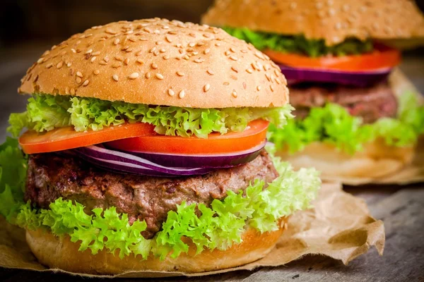 Huisgemaakte hamburger met verse groene sla, tomaten en rode uien — Stockfoto