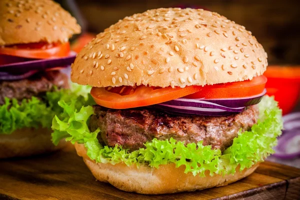 Huisgemaakte hamburger met verse groene sla, tomaten en rode ui close-up — Stockfoto