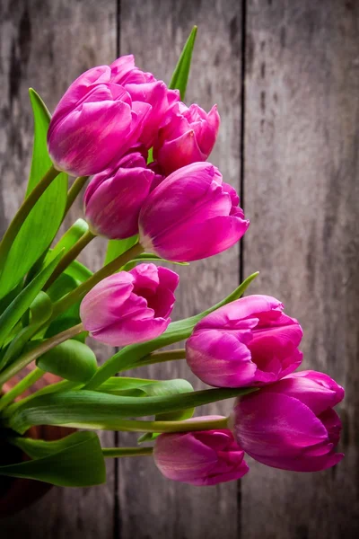 Букет розовых тюльпанов на деревянном фоне — стоковое фото
