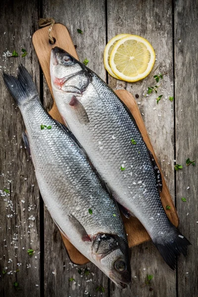 iki ham taze deniz levreği limon ve deniz bir kesme tahtası üzerinde tuz 