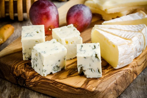 Fromage bleu et camembert en gros plan sur une planche de bois — Photo