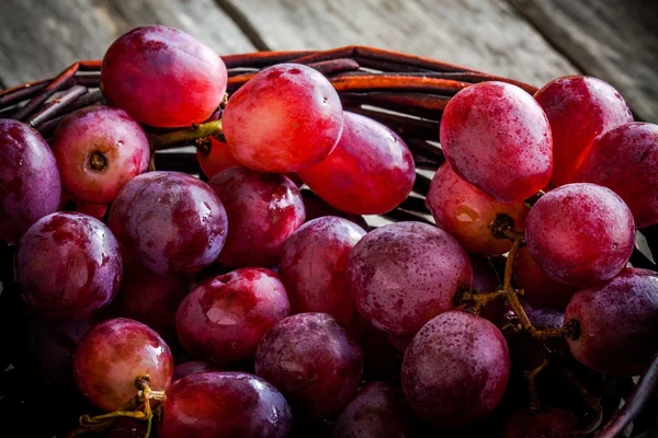 Uvas maduras orgânicas no cesto da mesa de madeira — Fotografia de Stock