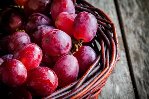 Uvas maduras orgânicas no cesto da mesa de madeira — Fotografia de Stock