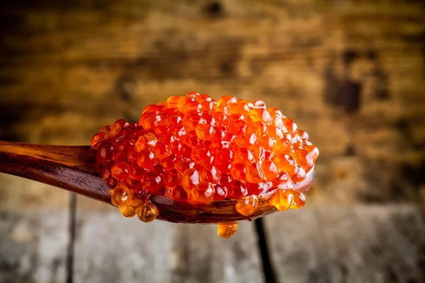 Caviale rosso fresco in un cucchiaio di legno — Foto Stock