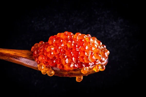 Caviar vermelho fresco em uma colher de madeira — Fotografia de Stock