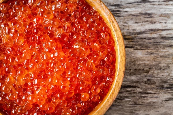 Caviale rosso fresco in una ciotola di legno primo piano — Foto Stock