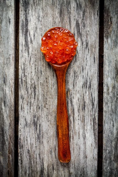 Fresh red caviar in a wooden spoon — Stock Photo, Image