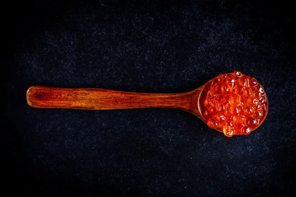Caviar vermelho fresco em uma colher de madeira — Fotografia de Stock