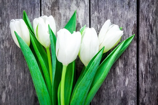 Ramo de tulipanes blancos sobre un fondo rústico — Foto de Stock
