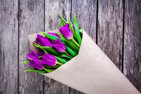 Букет фиолетовых тюльпанов на деревенском фоне — стоковое фото